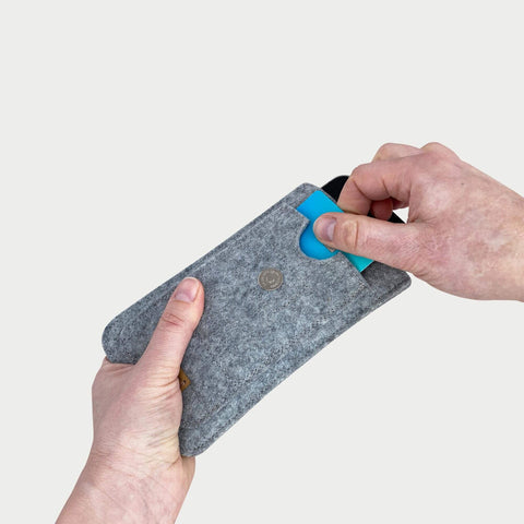 Handytasche für Samsung Galaxy S25 FE in hellgrau, zeigt das Herausziehen einer Karte aus der Hülle.