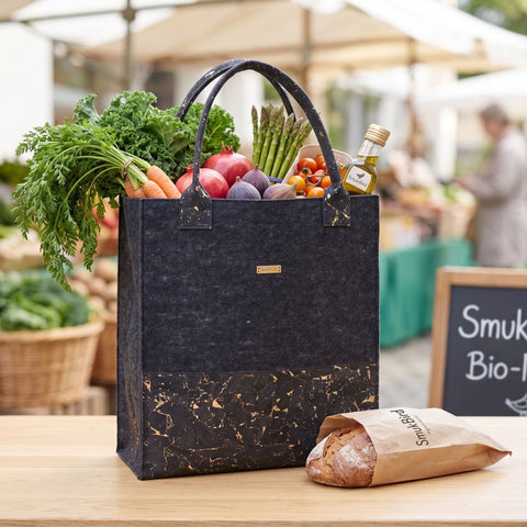 Dunkle Filz Shopper Tasche gefüllt mit Brot und Gemüse auf dem Wochenmarkt, nachhaltige Tasche für den täglichen Einkauf